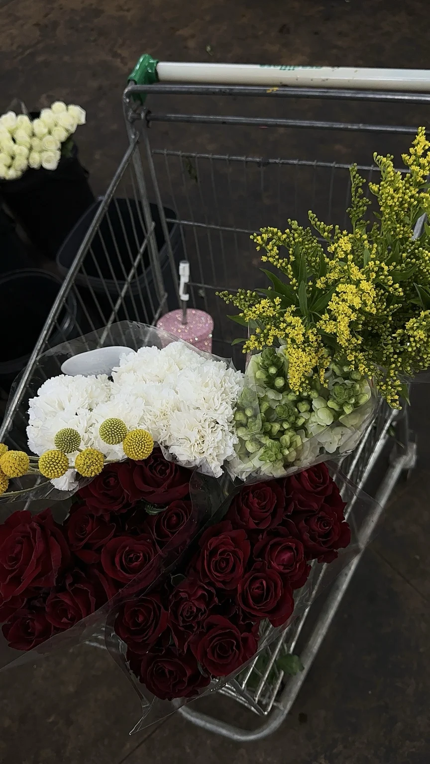 A selection of red roses, white carnations, green blooms and yellow accents during sourcing